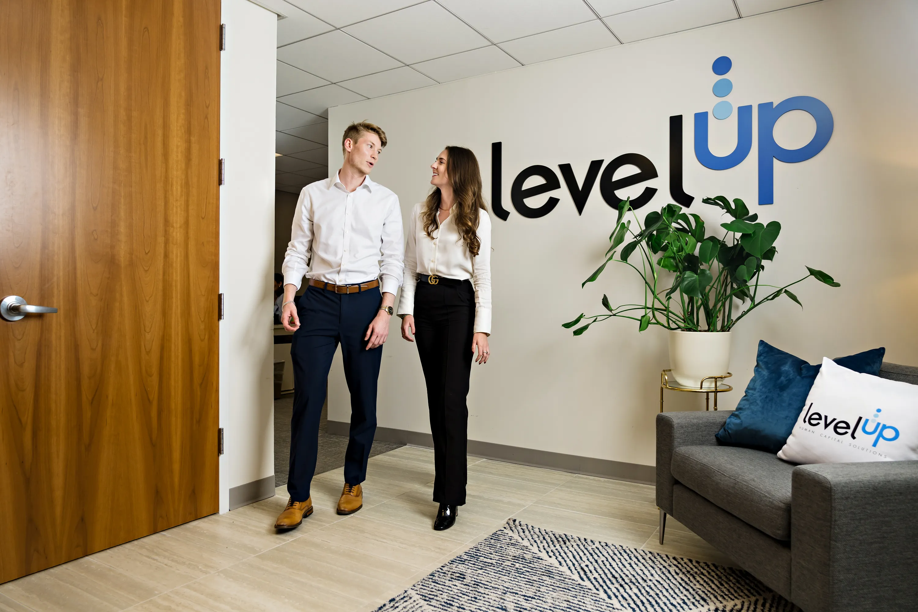 Trabajadores masculinos y femeninos hablando en la oficina de LevelUP.