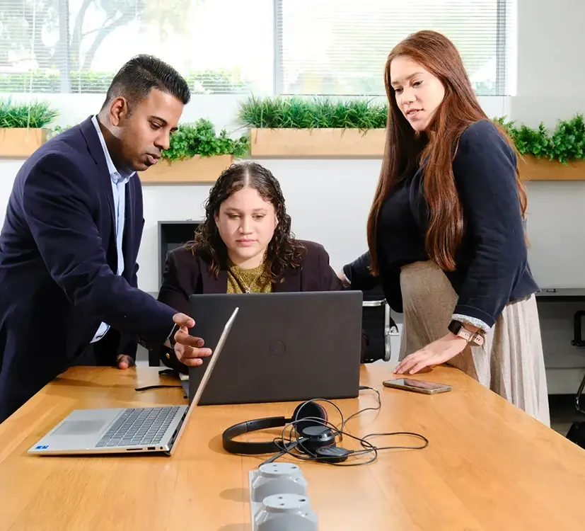 Group of people sat round laptop