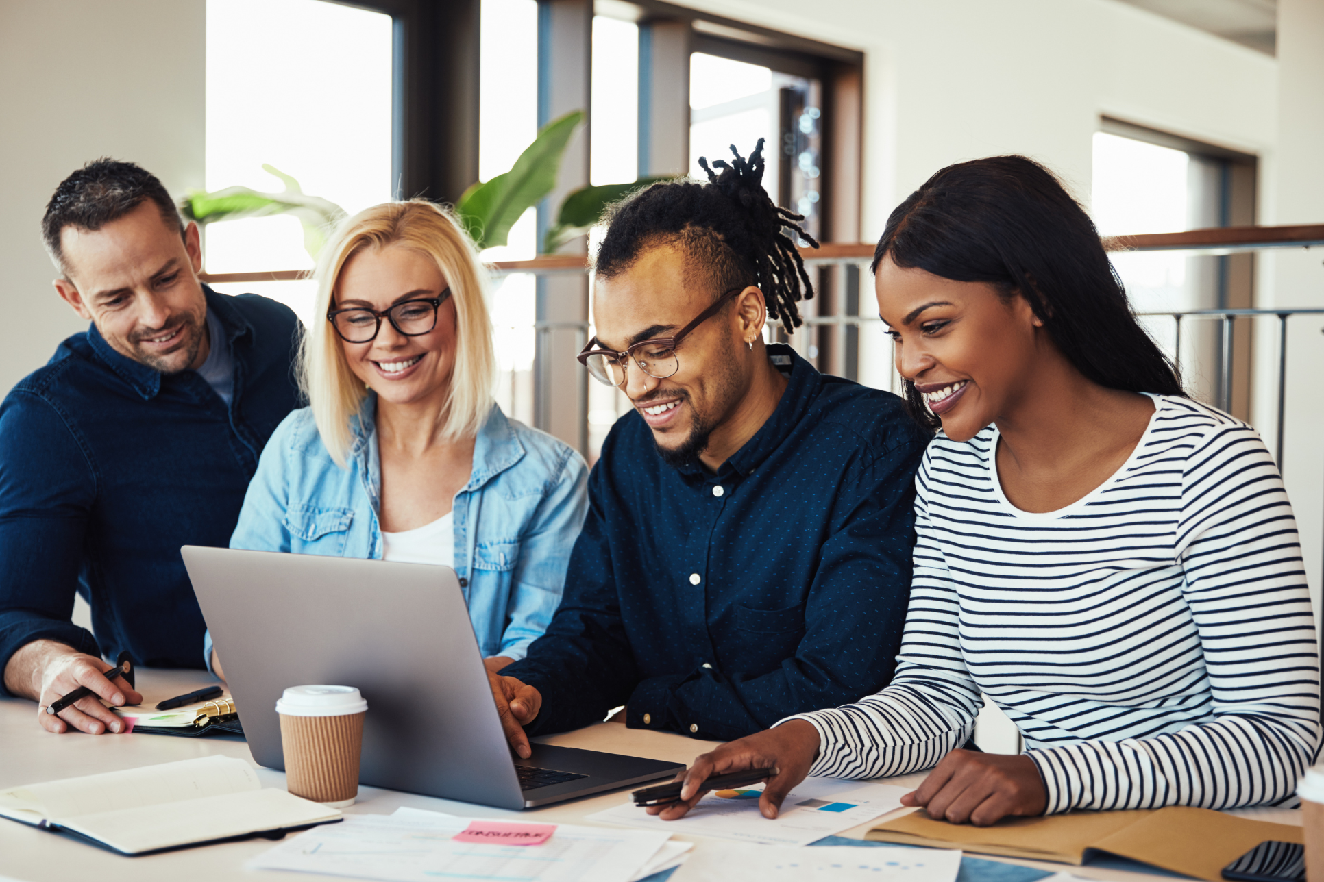 group of people sat around a laptop